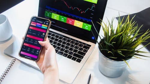 Phone and laptop showing trading and organized records