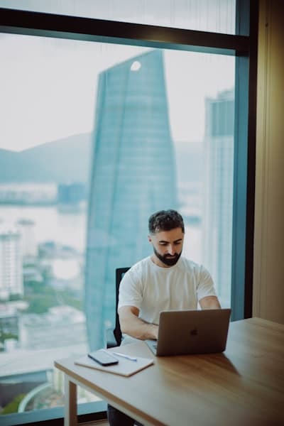 Business owner working on a laptop by a large window